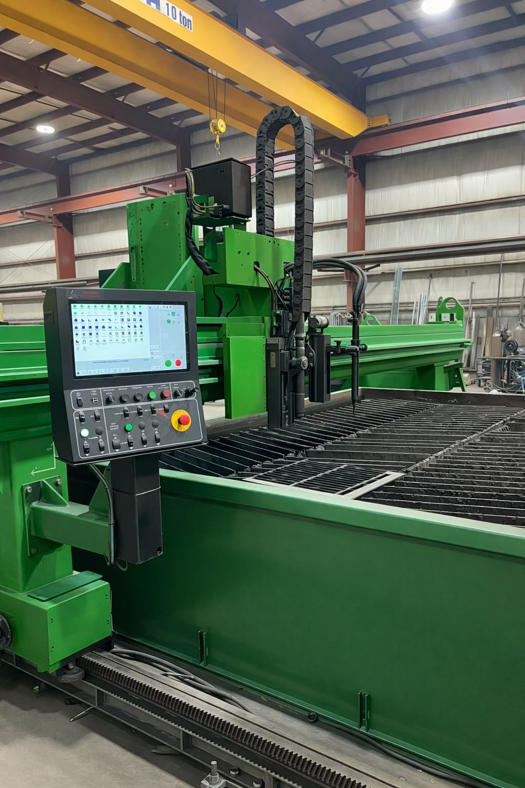 CNC plasma cutting table and control panel on the Regal Industrial shop floor, with overhead crane above
