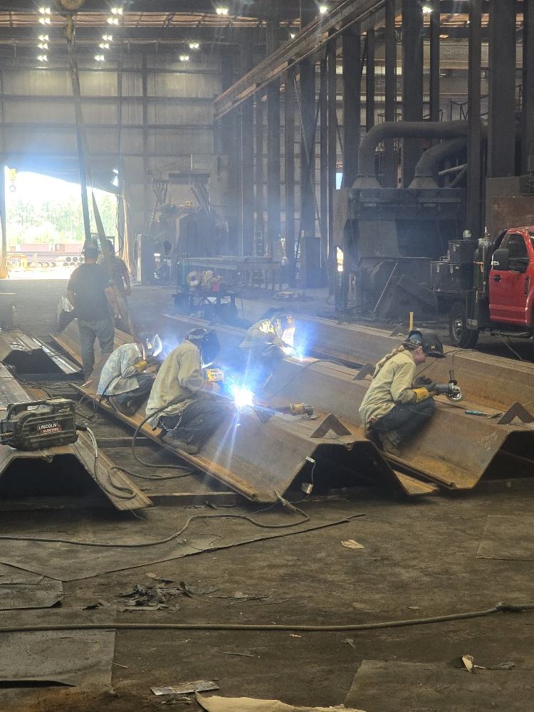 Welders fabricating steel pile sections on the Regal Industrial shop floor