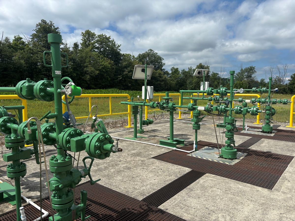 Coated wellheads, valves, and production piping on an in-service gas pad