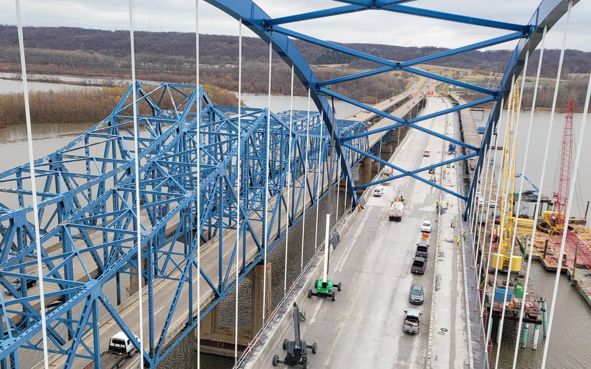 Field coating work on a steel arch bridge carrying highway traffic