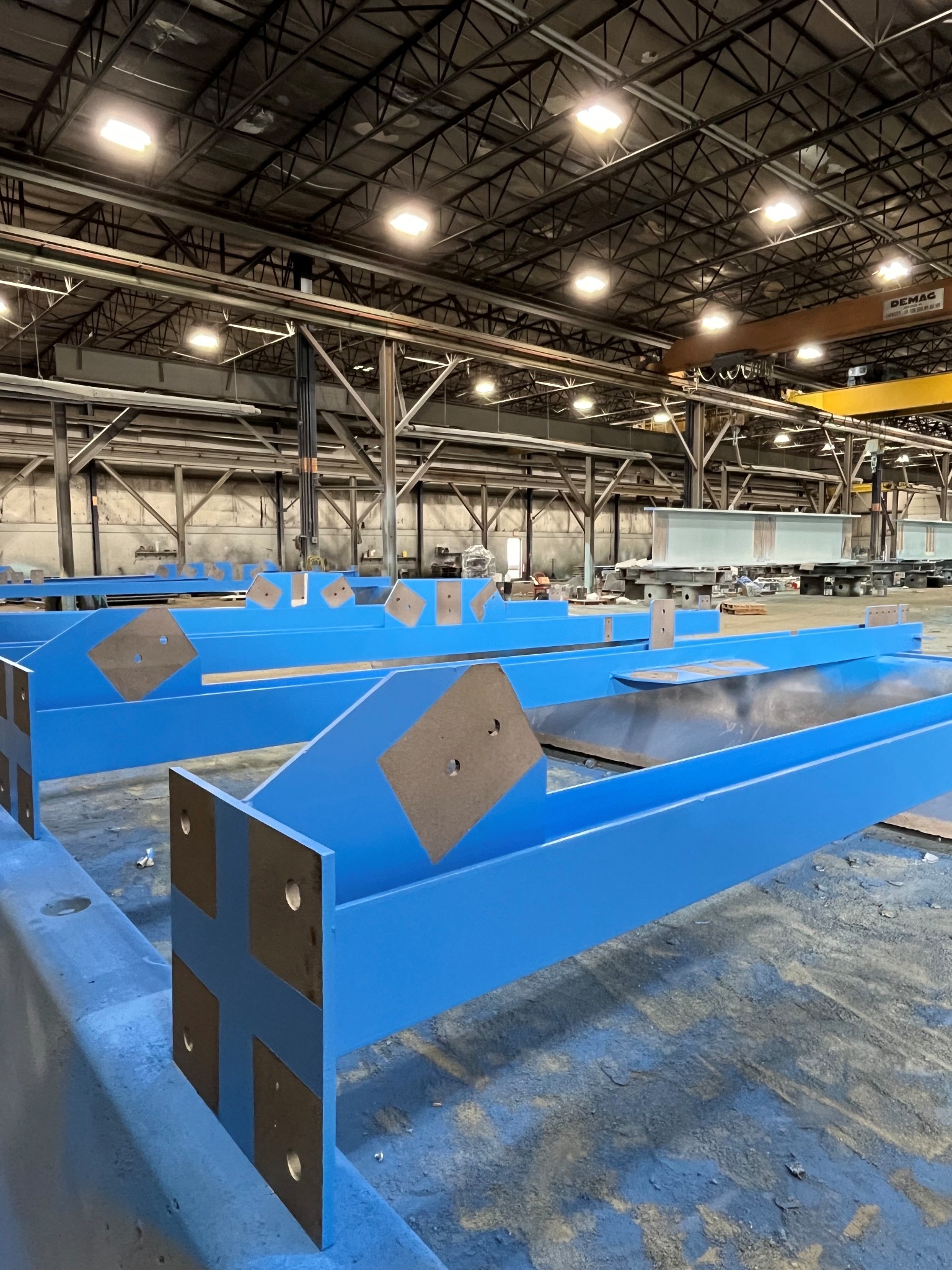 Blue coated structural steel members staged inside the Regal Industrial Millville shop