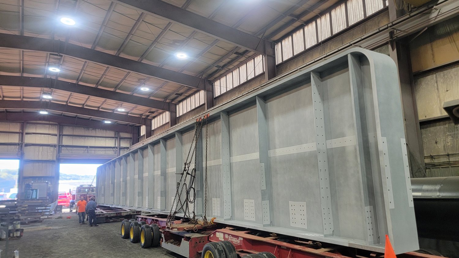 Coated bridge girder loaded on a multi-axle trailer inside the Regal Industrial shop bay