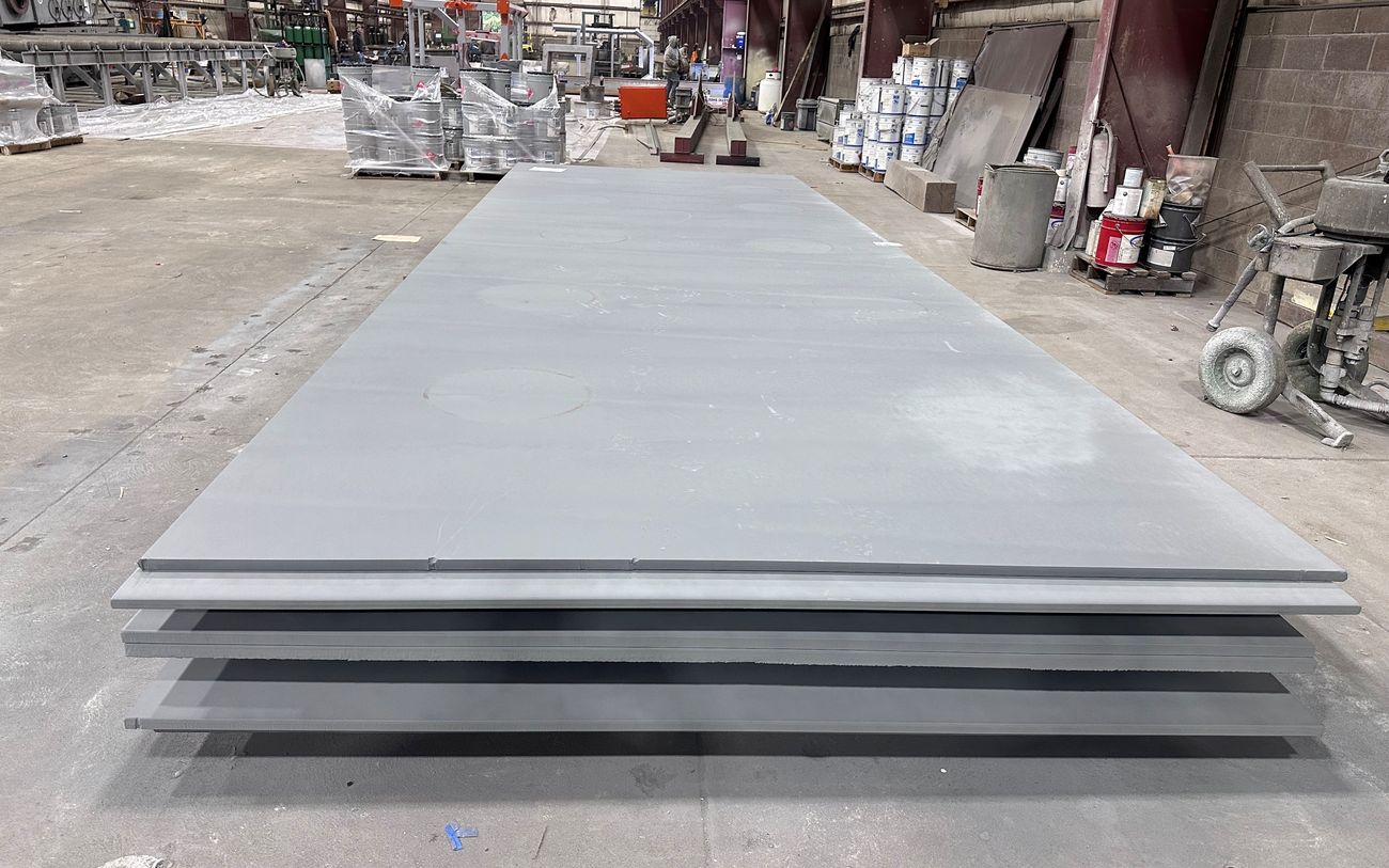 Stack of blasted and primed steel plate on the shop floor at Regal Industrial Donora