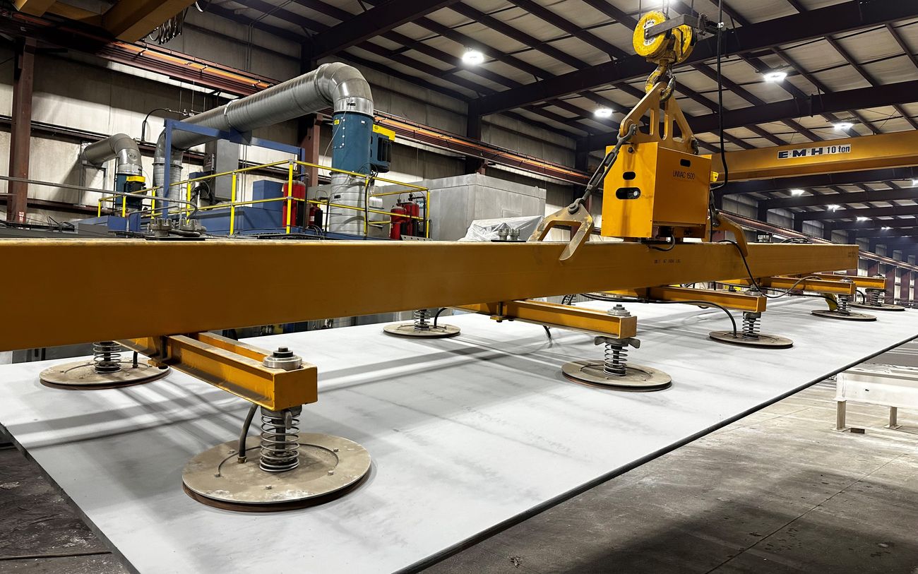 Vacuum lifting equipment handling a blasted and primed steel plate at Regal Industrial