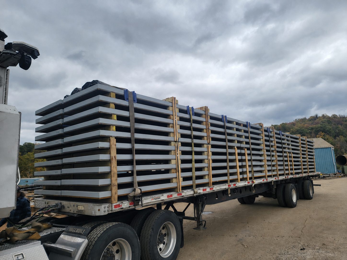 Banded stacks of coated steel plate blocked and strapped on a flatbed trailer at the Regal Industrial yard